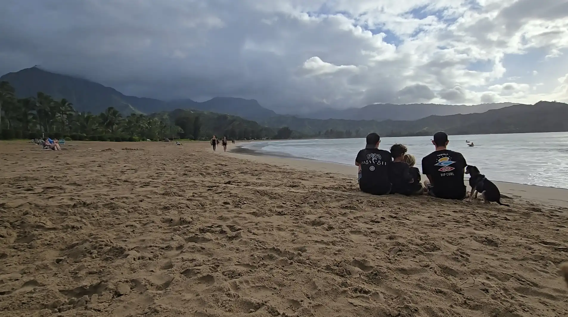 family sitting at hanalei bay